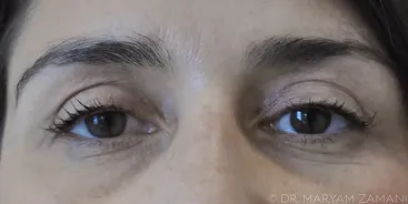 Close-up of a woman's eyes with long lashes and well-defined eyebrows.