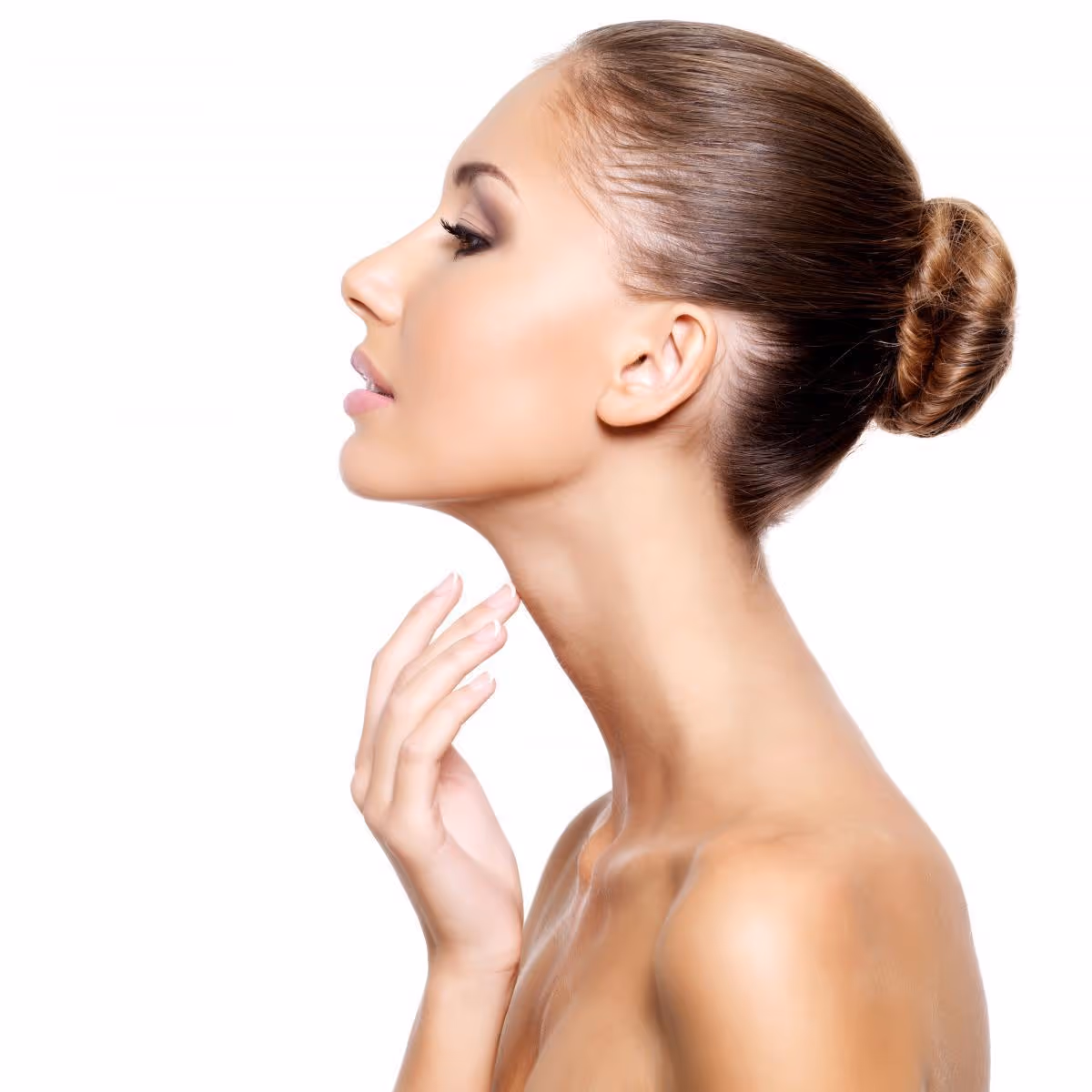 Profile of a woman with a brown hair bun gently touching her neck against a white background.